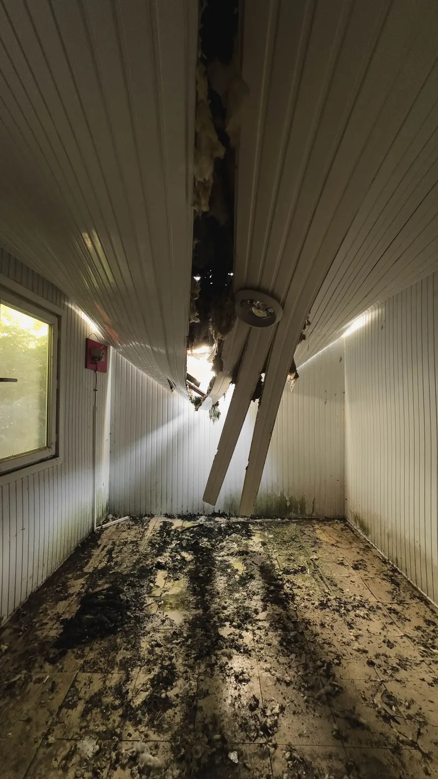 Hallway where a soaked ceiling has fallen onto the floor