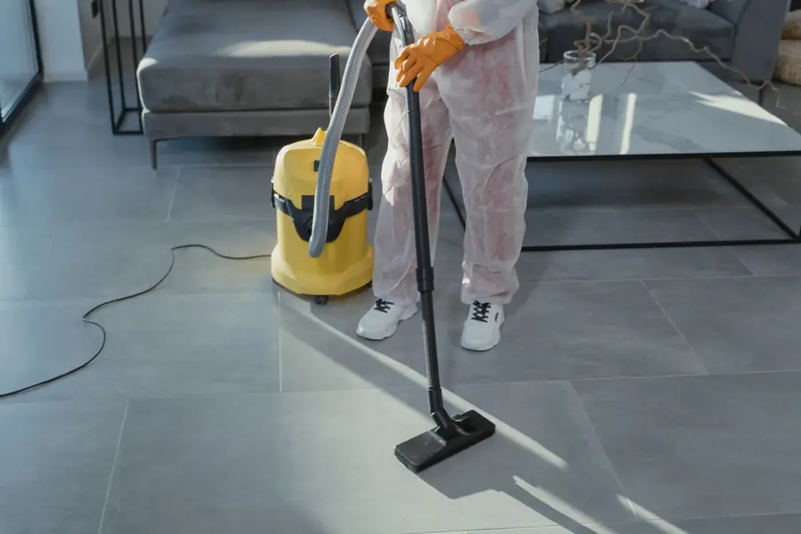 Technician running a wet vacuum across a tile floor